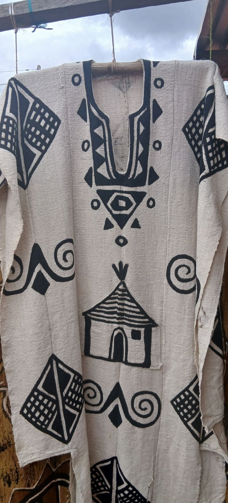 Weiße Bogolan-Tunika mit schwarz aufgemalten geometrischen Zeichen