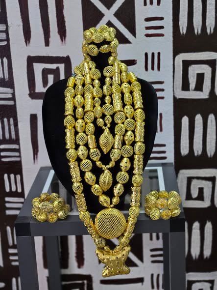 Mehrreihige Kette aus goldfarbenen Perlen mit großem Anhänger und passenden Armbändern