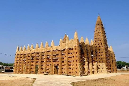 Moschee aus Lehm im Sudanstil mit Kegeltürmen und herausstehenden Holzstreben