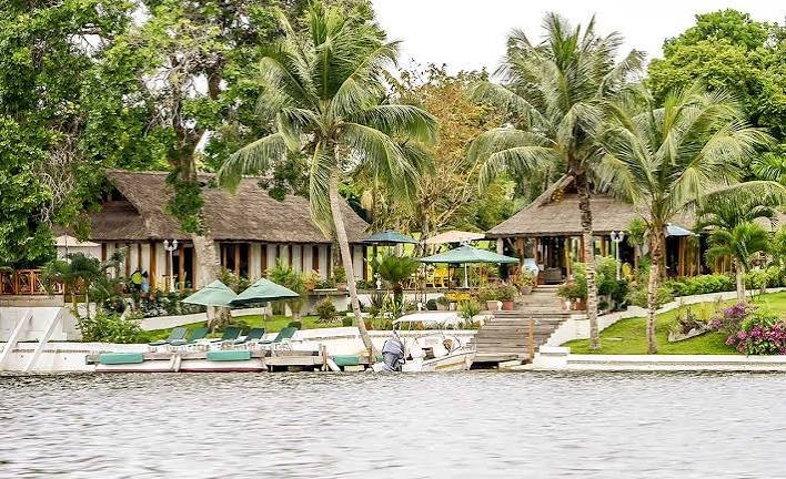 Bungalows mit Strohdächern und Steg direkt am Lagunenufer