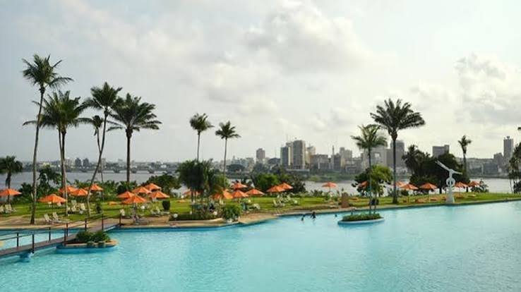 Palmen und Liegen am Wasser mit der Skyline des Plateau im Hintergrund