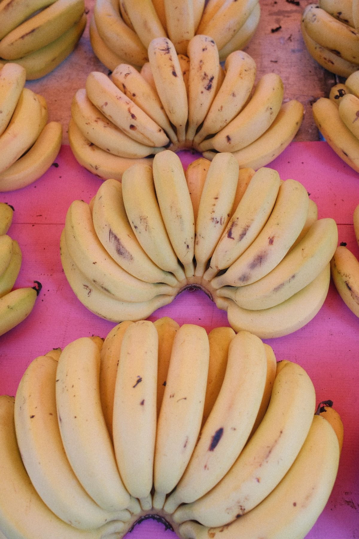 Bananenhände auf einem rosa Verkaufstisch