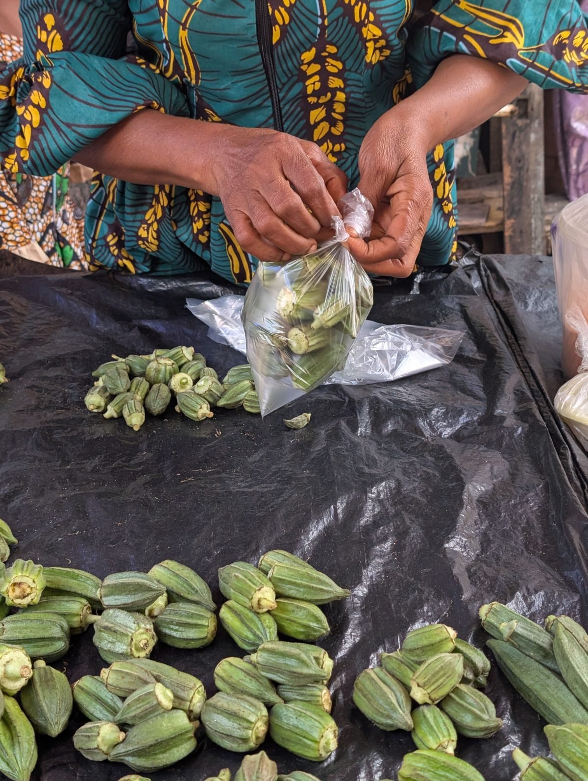 Händlerin füllt Okra in eine Tüte