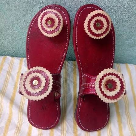 Paar rote Ledersandalen mit geflochtenen Kreismotiven