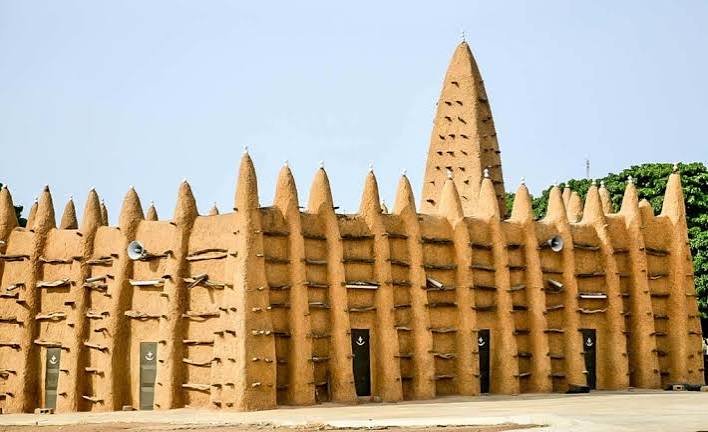 Lehmmoschee im Sudanstil mit Kegelminarett und herausstehenden Holzstreben