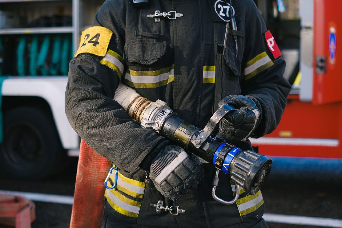 Feuerwehrmann in Schutzkleidung hält ein Strahlrohr