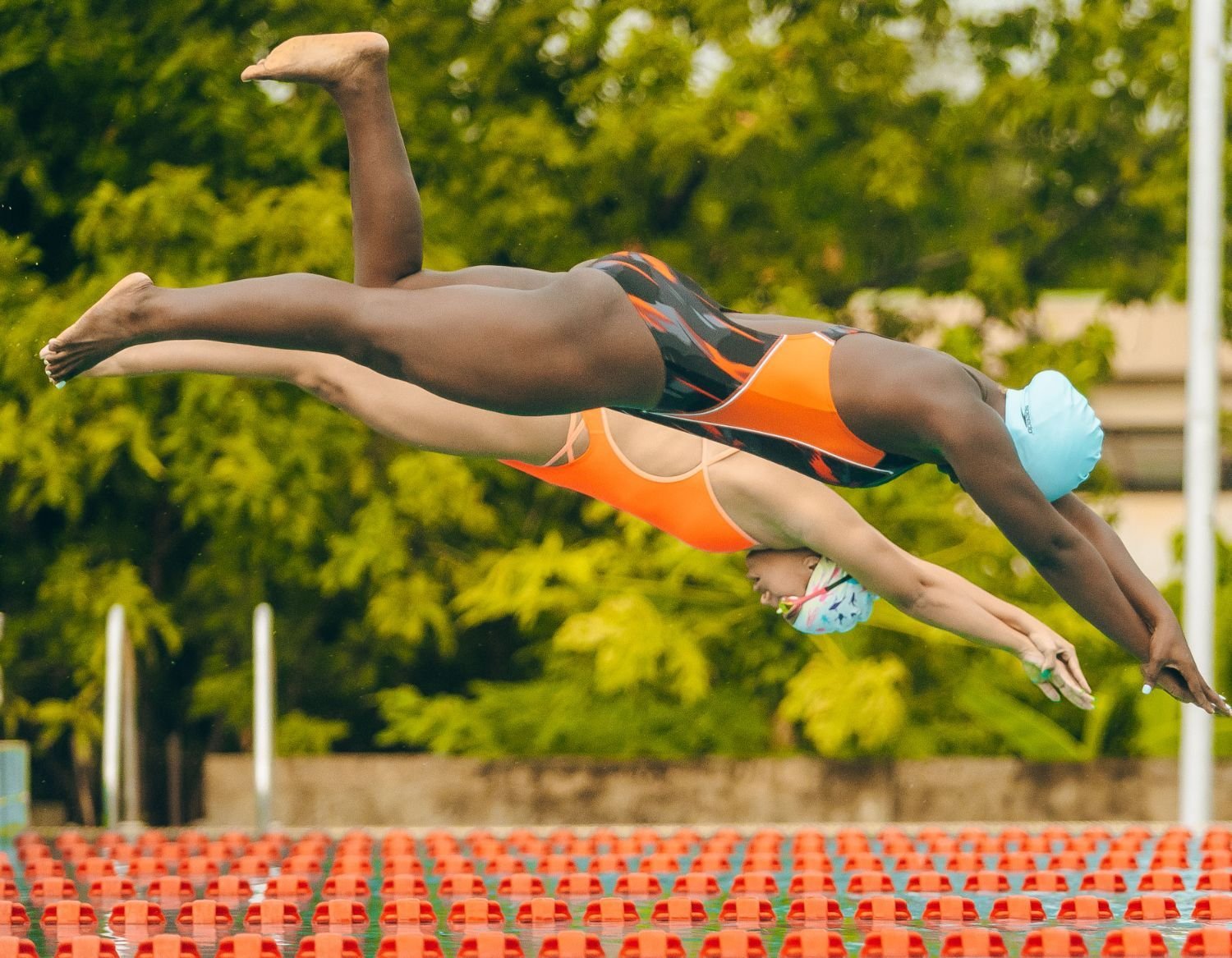 Zwei Schwimmerinnen im Startsprung über dem Becken