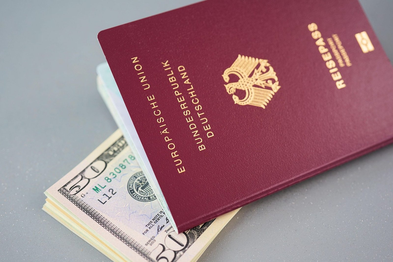 Deutscher Reisepass mit Geldscheinen als Symbol für die Visumgebühr